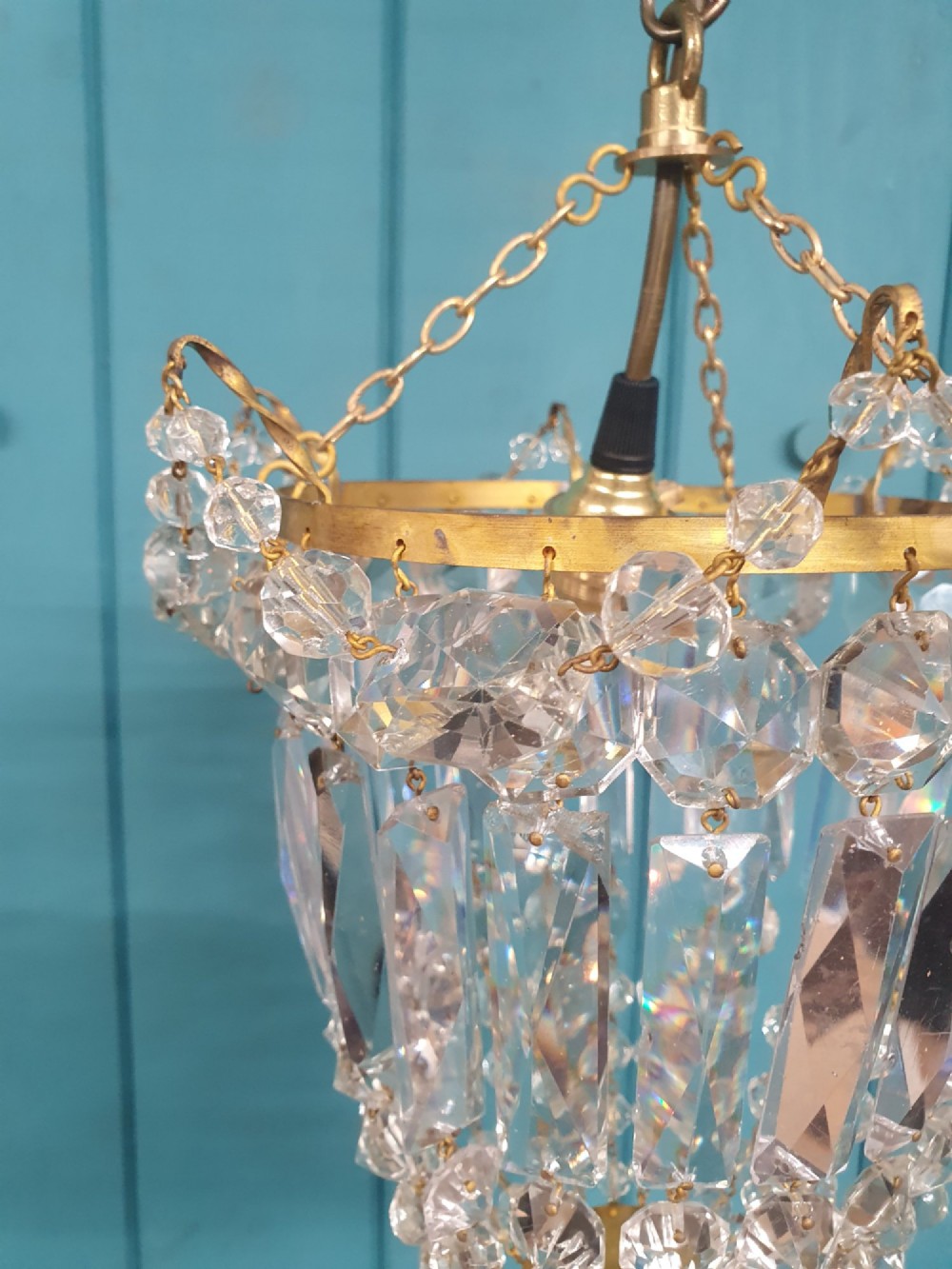 An early 20th-century gilt brass and crystal bag chandelier suspended by a link chain, featuring cascading faceted prisms and glass bead strands. View III
