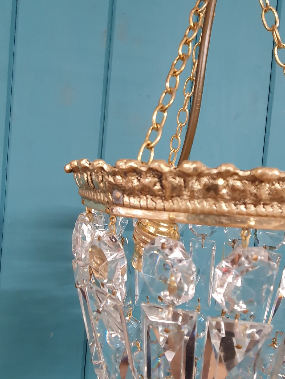 An early twentieth-century gilt brass crystal basket chandelier featuring faceted glass prisms and a suspended chain hanger. View IV