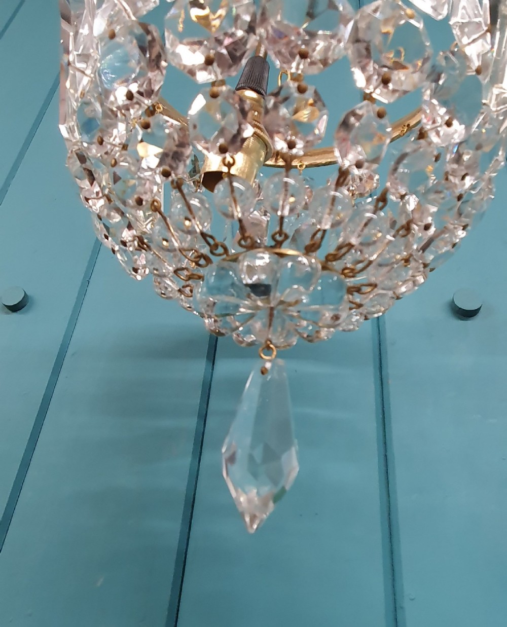 An early twentieth-century gilt brass crystal basket chandelier featuring faceted glass prisms and a suspended chain hanger. View VII
