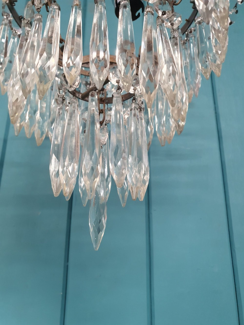 An early 20th century brass light fitting featuring cascading tiers of cut glass crystal teardrops suspended from brass chains. View III