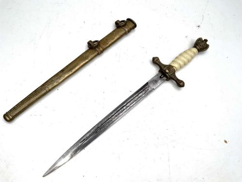 A German Kriegsmarine officer dress dagger featuring a cream wire-wrapped grip, spherical eagle pommel, crossguard, and an engraved brass scabbard with two suspension rings. View VII