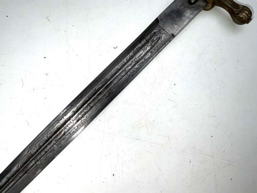 A German Kriegsmarine officer dress dagger featuring a cream wire-wrapped grip, spherical eagle pommel, crossguard, and an engraved brass scabbard with two suspension rings. View IX