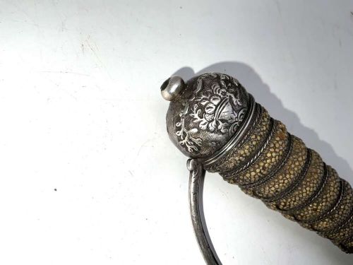 An early 18th-century short sword featuring a silvered hilt and ribbed grip, displayed alongside its black leather scabbard. View III
