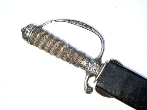 An early 18th-century short sword featuring a silvered hilt and ribbed grip, displayed alongside its black leather scabbard. View VII