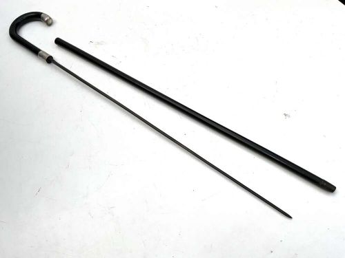 A black ebonised wooden walking stick featuring a curved crook handle, a silver-toned metal collar, and a protective tip. View IV