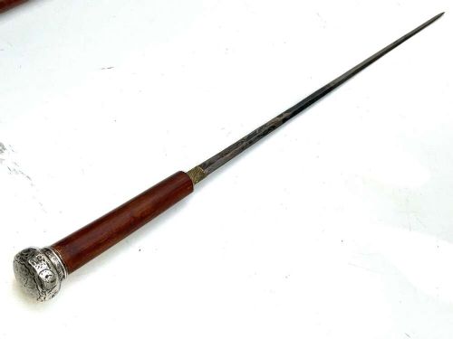A tapered dark wooden swagger stick featuring a polished silver-toned metal pommel cap and a protective metal ferrule. View III