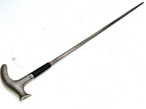 A Victorian dark wood walking cane featuring a decorative silver handle and a brass protective ferrule at the base. View VI