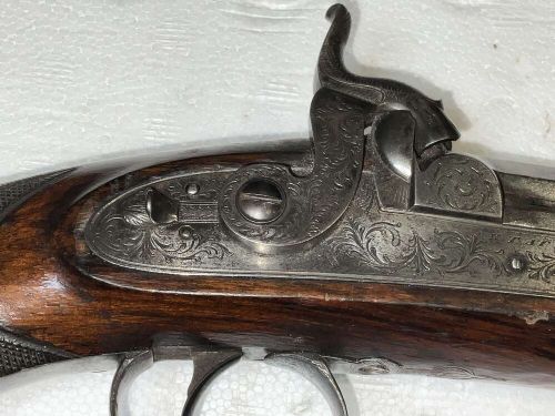 A pair of nineteenth-century percussion pistols featuring dark walnut stocks, octagonal steel barrels, engraved lockplates, and captive swivel ramrods. View VI