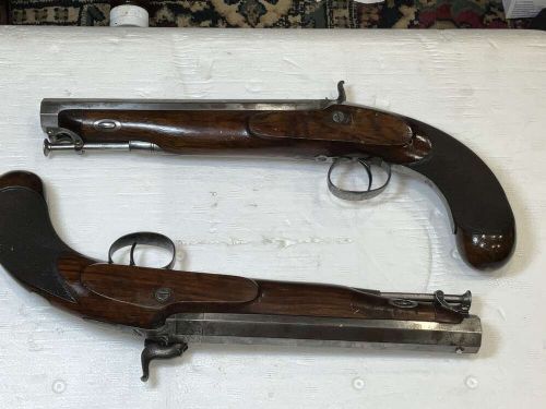 A pair of nineteenth-century percussion pistols featuring dark walnut stocks, octagonal steel barrels, engraved lockplates, and captive swivel ramrods. View VII