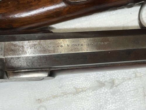 A pair of nineteenth-century percussion pistols featuring dark walnut stocks, octagonal steel barrels, engraved lockplates, and captive swivel ramrods. View VIII