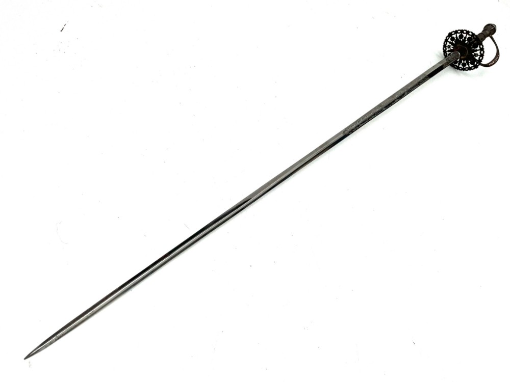 An 18th-century rapier sword featuring a dark leather scabbard and an intricately pierced round steel hilt guard. View VII