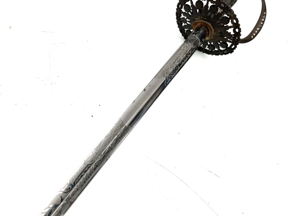 An 18th-century rapier sword featuring a dark leather scabbard and an intricately pierced round steel hilt guard. View VIII