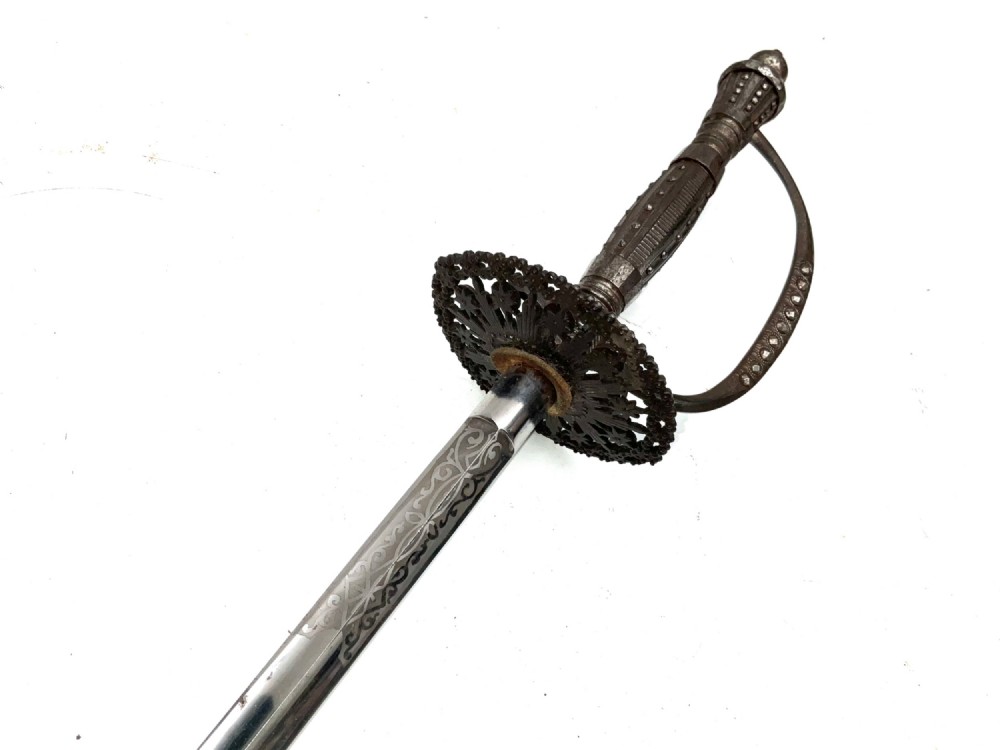 An 18th-century rapier sword featuring a dark leather scabbard and an intricately pierced round steel hilt guard. View IX
