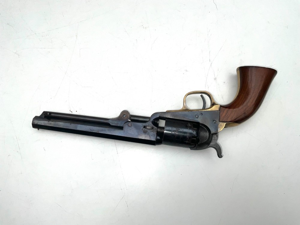 An open fitted wooden presentation case containing a .31 calibre percussion revolver, a brass powder flask, a bullet mould, and an instruction label attached to the inner lid. View III