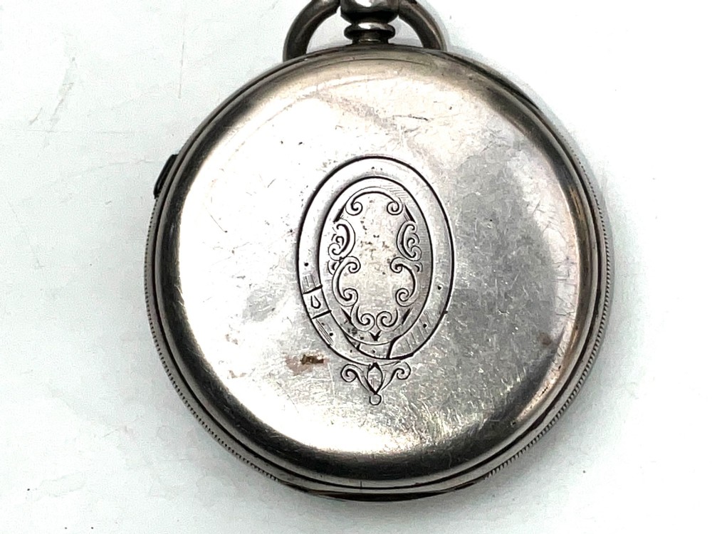 An antique silver open-face pocket watch featuring a white enamel dial with Roman numerals, centre seconds chronograph markings, and an attached top suspension loop. View III