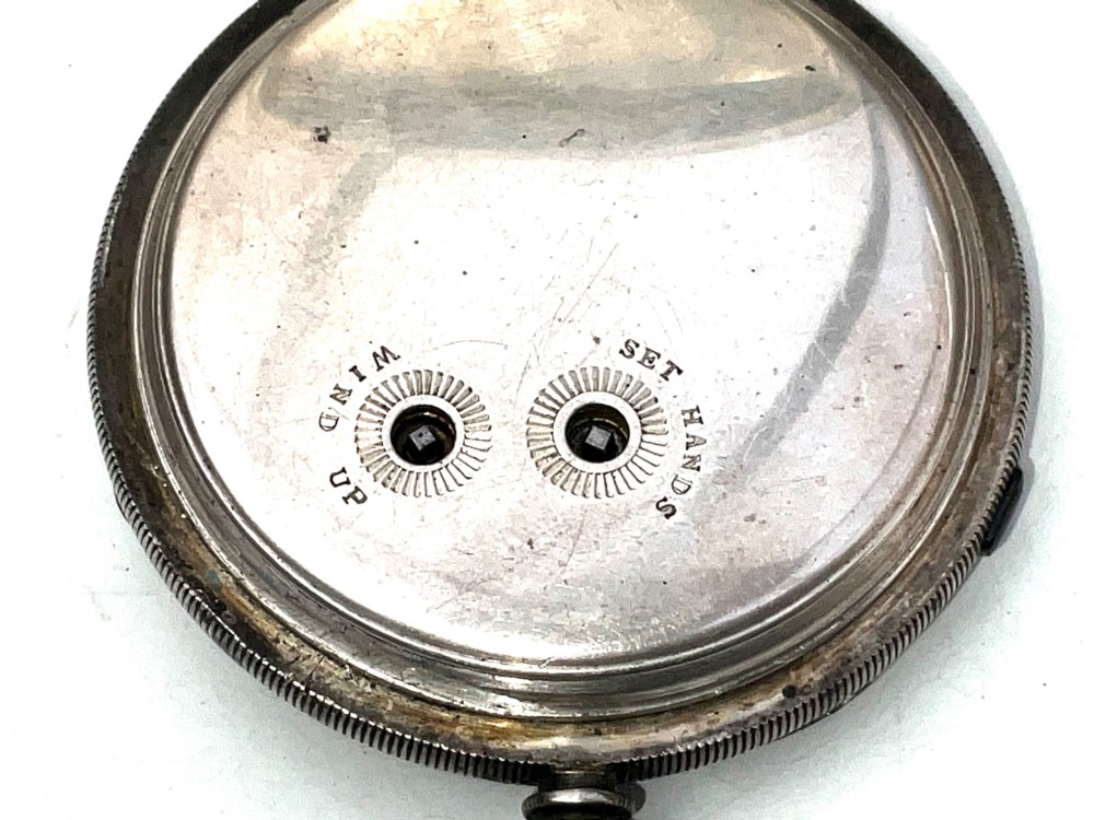 An antique silver open-face pocket watch featuring a white enamel dial with Roman numerals, centre seconds chronograph markings, and an attached top suspension loop. View IV