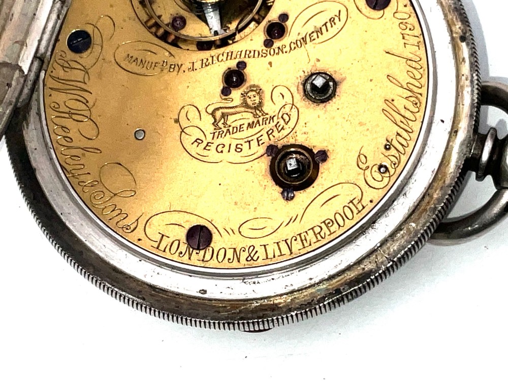 An antique silver open-face pocket watch featuring a white enamel dial with Roman numerals, centre seconds chronograph markings, and an attached top suspension loop. View VI