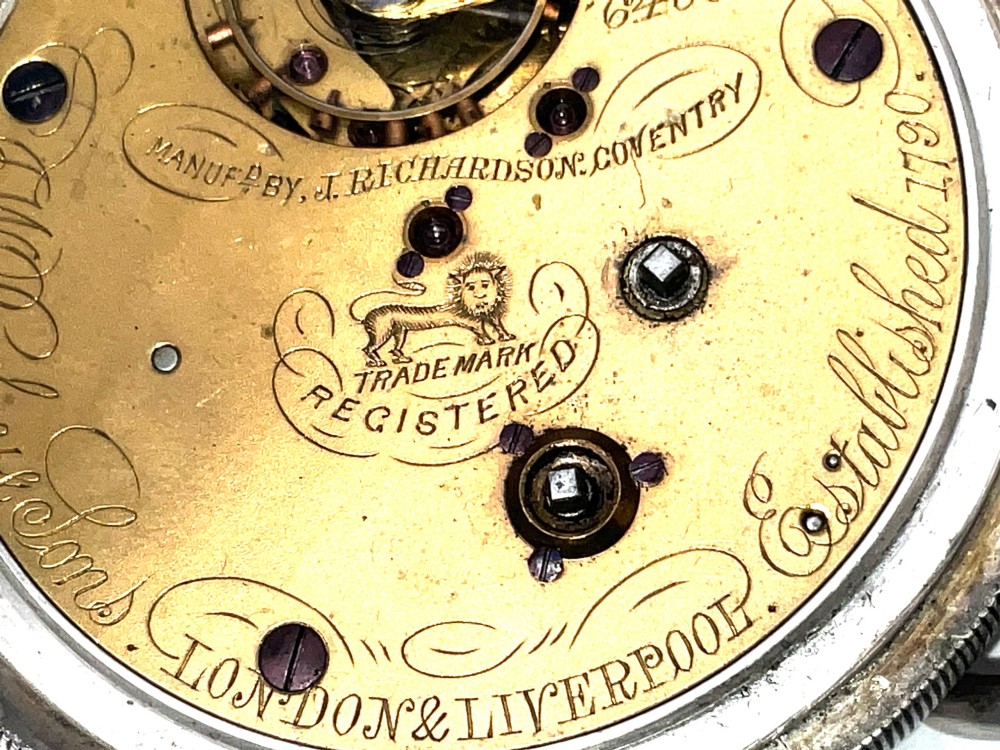 An antique silver open-face pocket watch featuring a white enamel dial with Roman numerals, centre seconds chronograph markings, and an attached top suspension loop. View VII