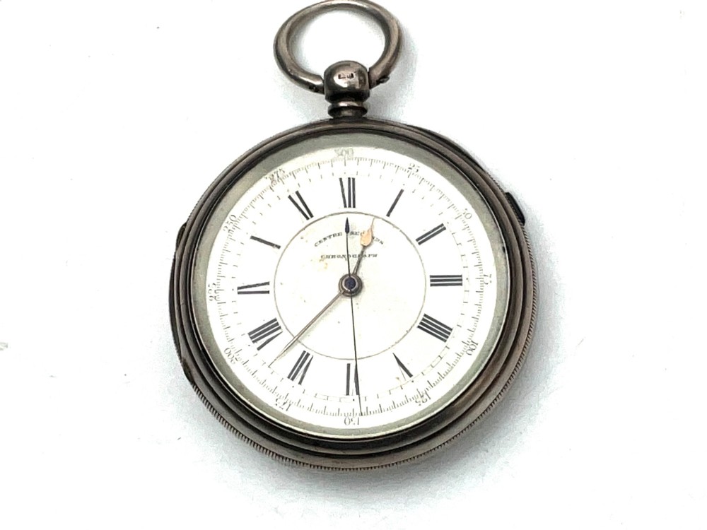 An antique silver open-face pocket watch featuring a white enamel dial with Roman numerals, centre seconds chronograph markings, and an attached top suspension loop. View XII
