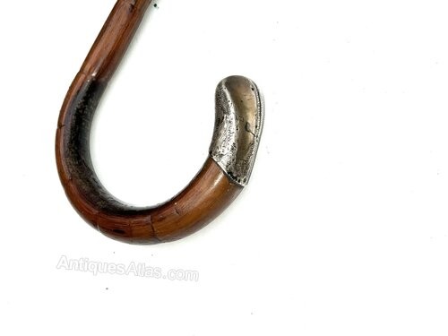 An antique gentlemens partridge wood walking stick unsheathed to reveal a long, thin steel blade. View II
