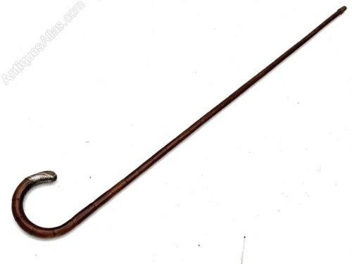 An antique gentlemens partridge wood walking stick unsheathed to reveal a long, thin steel blade. View III
