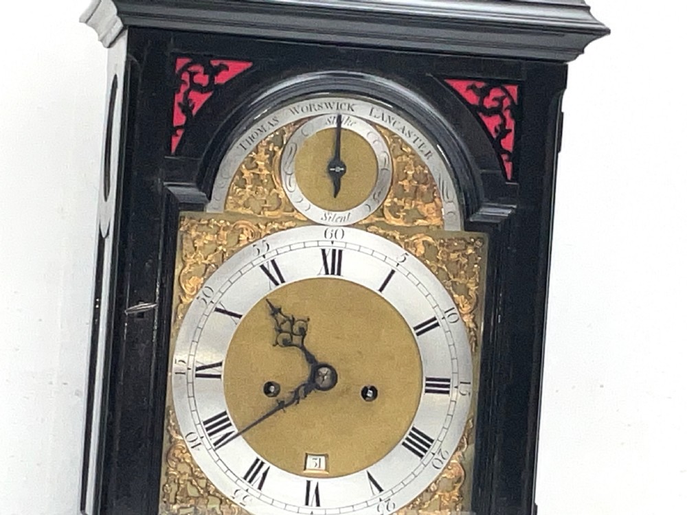 An eighteenth-century ebonised Georgian bracket clock featuring a brass carrying handle, an arched glass front door, and a brass dial with silvered chapter ring. View III