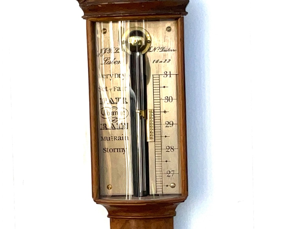 A wall-mounted antique Georgian stick barometer crafted from figured satinwood, featuring a brass finial, pediment top, and glass-fronted silvered scale. View II