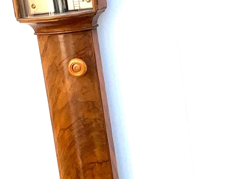 A wall-mounted antique Georgian stick barometer crafted from figured satinwood, featuring a brass finial, pediment top, and glass-fronted silvered scale. View IX