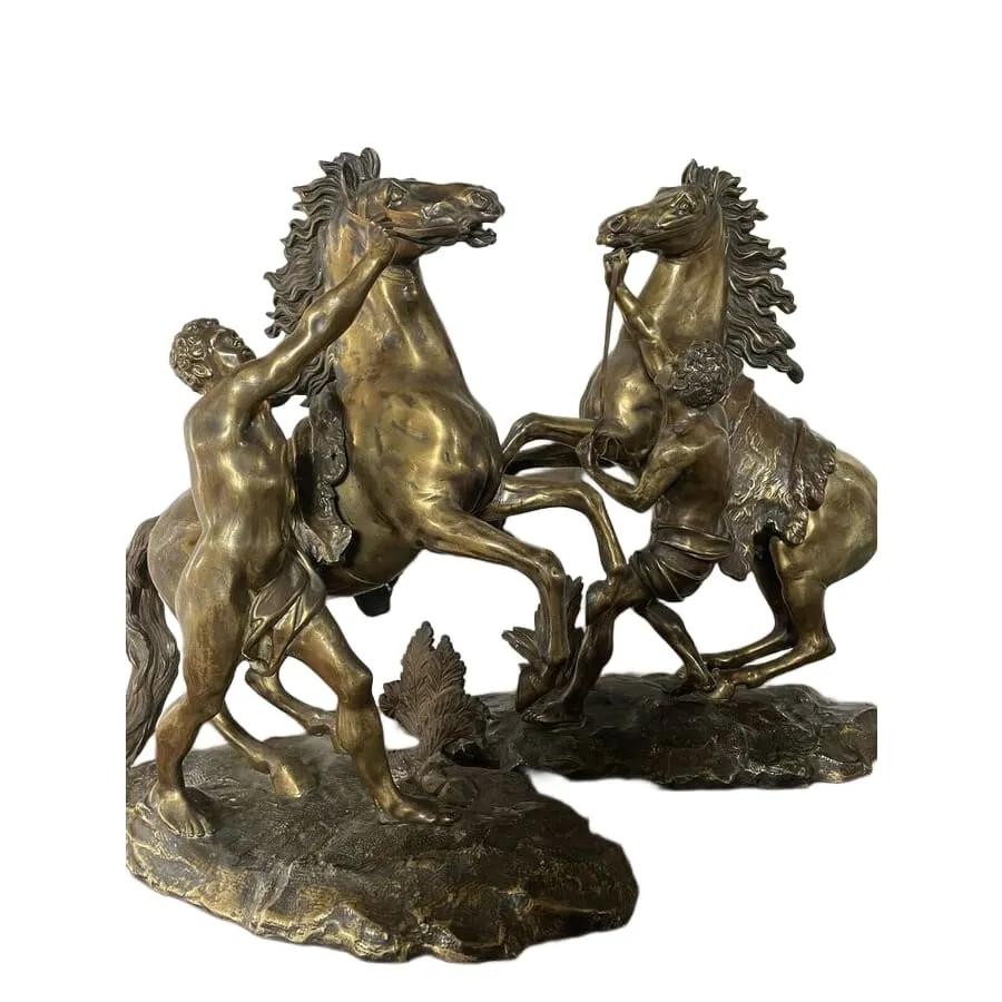A pair of detailed gilt-bronze sculptures depicting rearing horses held by classical male handlers on naturalistic bases. View II