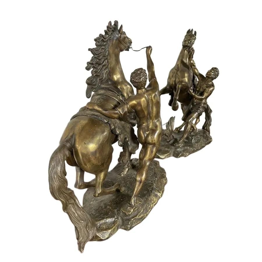 A pair of detailed gilt-bronze sculptures depicting rearing horses held by classical male handlers on naturalistic bases. View V