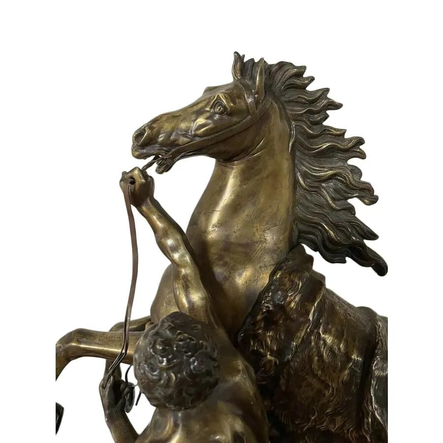 A pair of detailed gilt-bronze sculptures depicting rearing horses held by classical male handlers on naturalistic bases. View VI