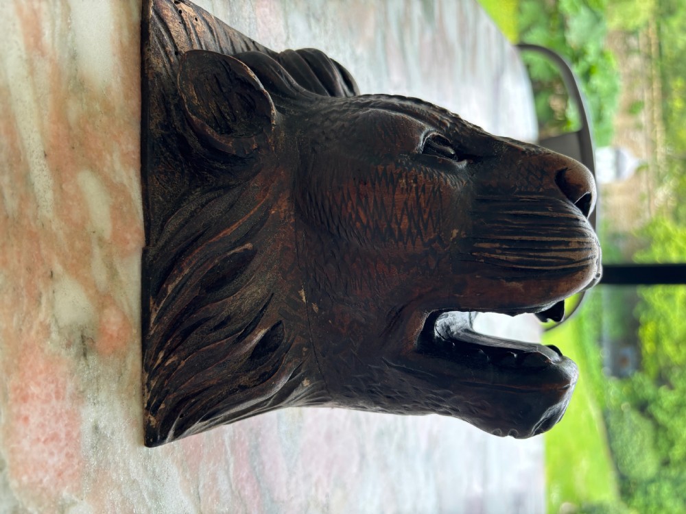 A hand-carved dark walnut wood tiger head featuring open jaws, textured fur detailing, and a flat rear mounting block. View III
