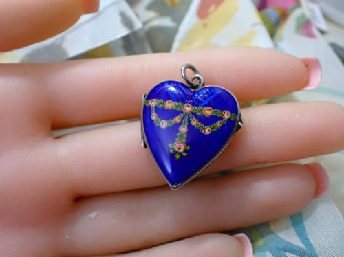 fig 1. A heart-shaped silver locket featuring cobalt blue guilloche enamel decorated with a hand-painted floral rose garland motif.