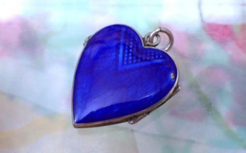 fig 2. A heart-shaped silver locket featuring cobalt blue guilloche enamel decorated with a hand-painted floral rose garland motif.
