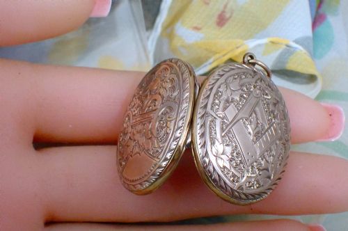 fig 2. An oval Victorian rose gold back and front locket featuring intricate hand-engraved scrollwork and floral motifs with a top suspension loop.