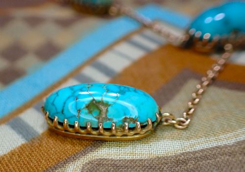 fig 3. An Edwardian 9ct rose gold negligee necklace set with five oval matrix turquoise cabochons suspended on fine trace chains.