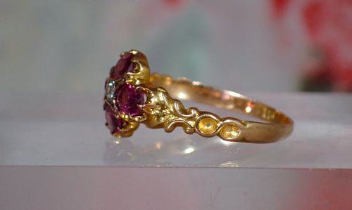 fig 2. An antique Victorian 15ct yellow gold ring featuring four oval almandine garnets centred around a single old-cut diamond with carved scroll shoulders.
