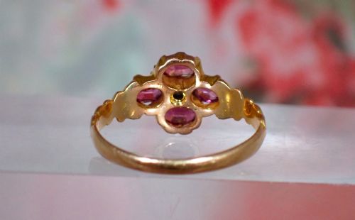 fig 3. An antique Victorian 15ct yellow gold ring featuring four oval almandine garnets centred around a single old-cut diamond with carved scroll shoulders.