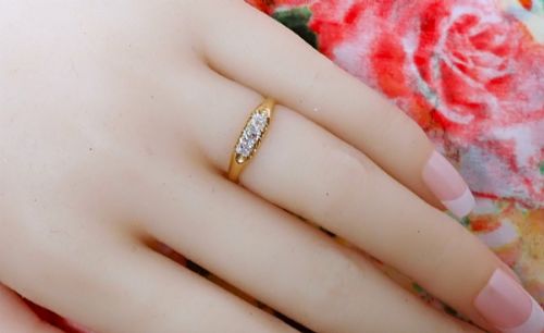fig 2. An 18ct yellow gold Victorian ring featuring three cushion cut diamonds set in a carved row along the band.