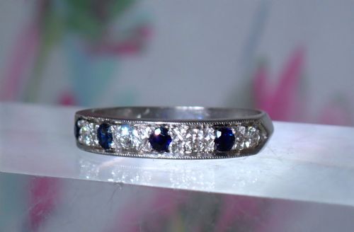 fig 2. A vintage 18ct white gold half eternity ring featuring alternating round dark blue sapphires and clear diamonds along the band.