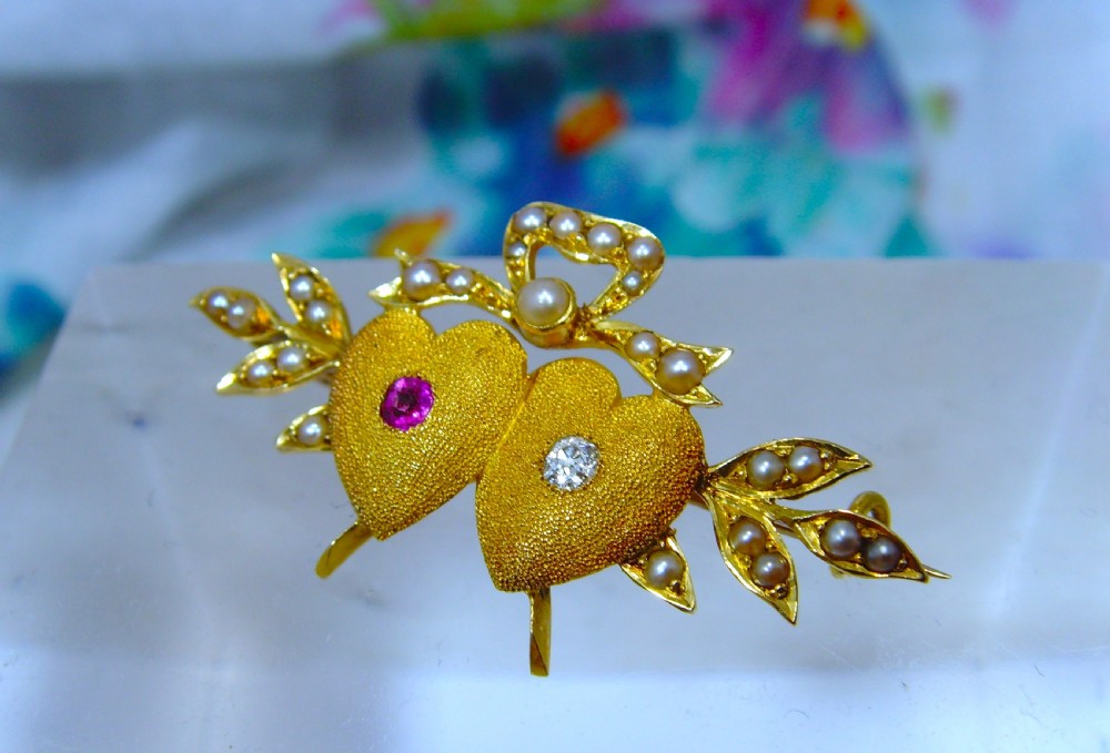 A Victorian 18ct yellow gold double heart brooch set with a ruby, a diamond, and seed pearl accents. View III
