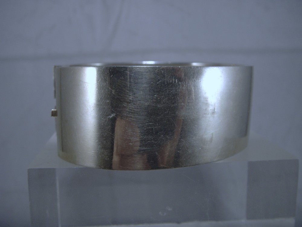A wide Victorian sterling silver hinged cuff bangle featuring engraved floral motifs, geometric patterns, and fan details. View VII
