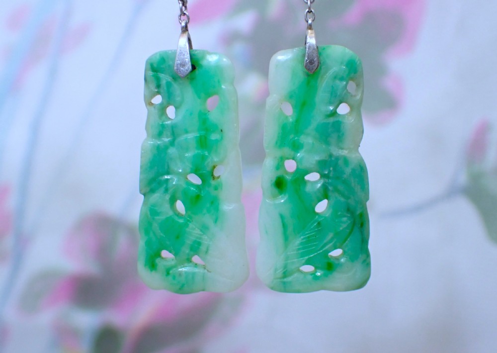 A pair of antique Art Deco drop earrings featuring pierced rectangular carved green jade plaques suspended from fine platinum link chains and pearls. View II
