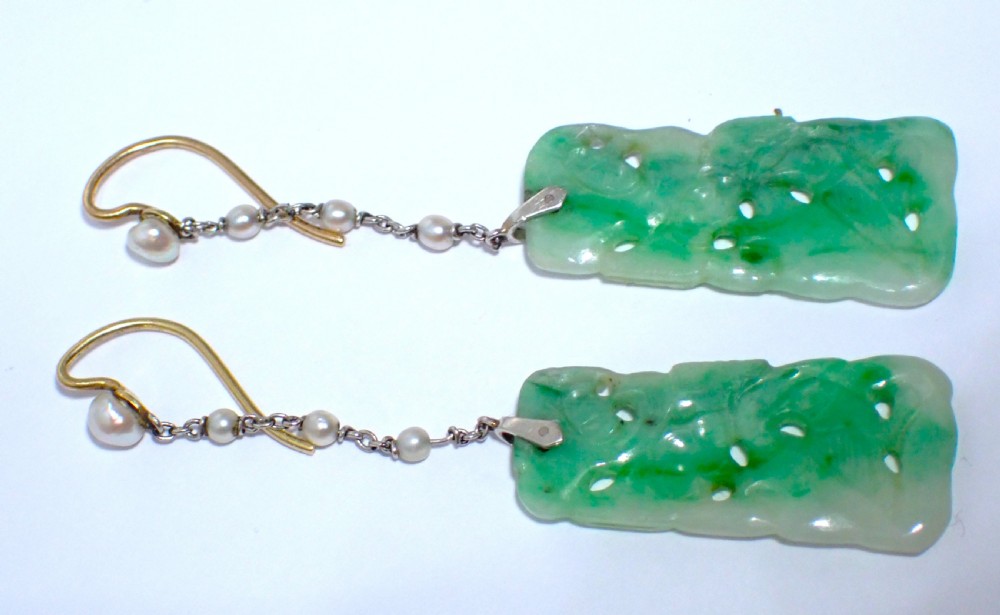 A pair of antique Art Deco drop earrings featuring pierced rectangular carved green jade plaques suspended from fine platinum link chains and pearls. View V