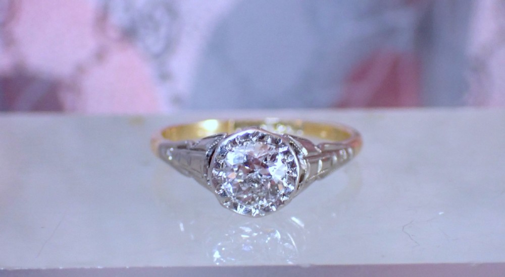 An Art Deco ring with a central diamond set in a platinum geometric head on an 18ct yellow gold band. View III