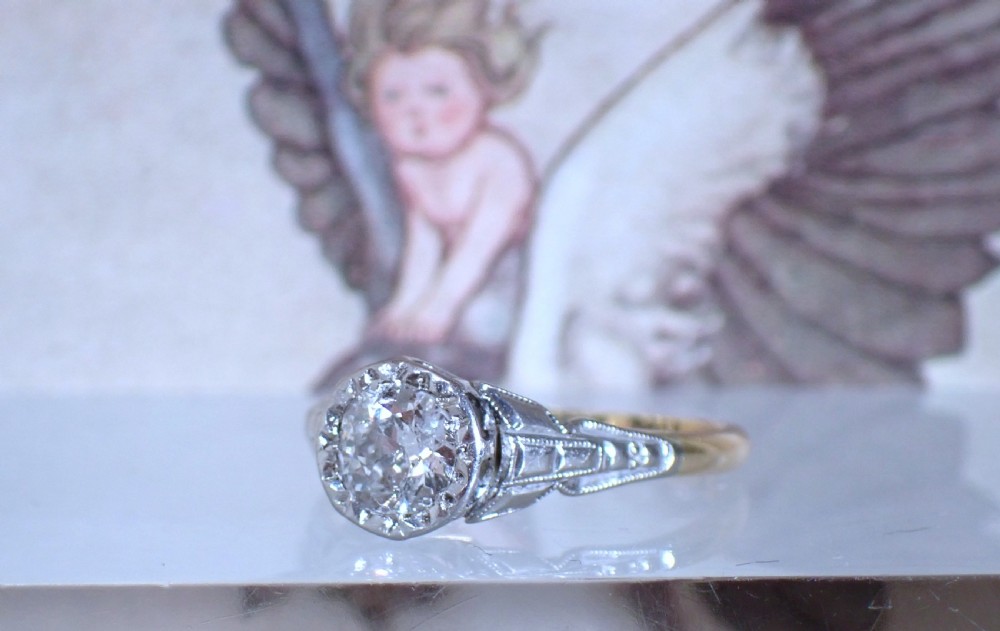 An Art Deco ring with a central diamond set in a platinum geometric head on an 18ct yellow gold band. View IV