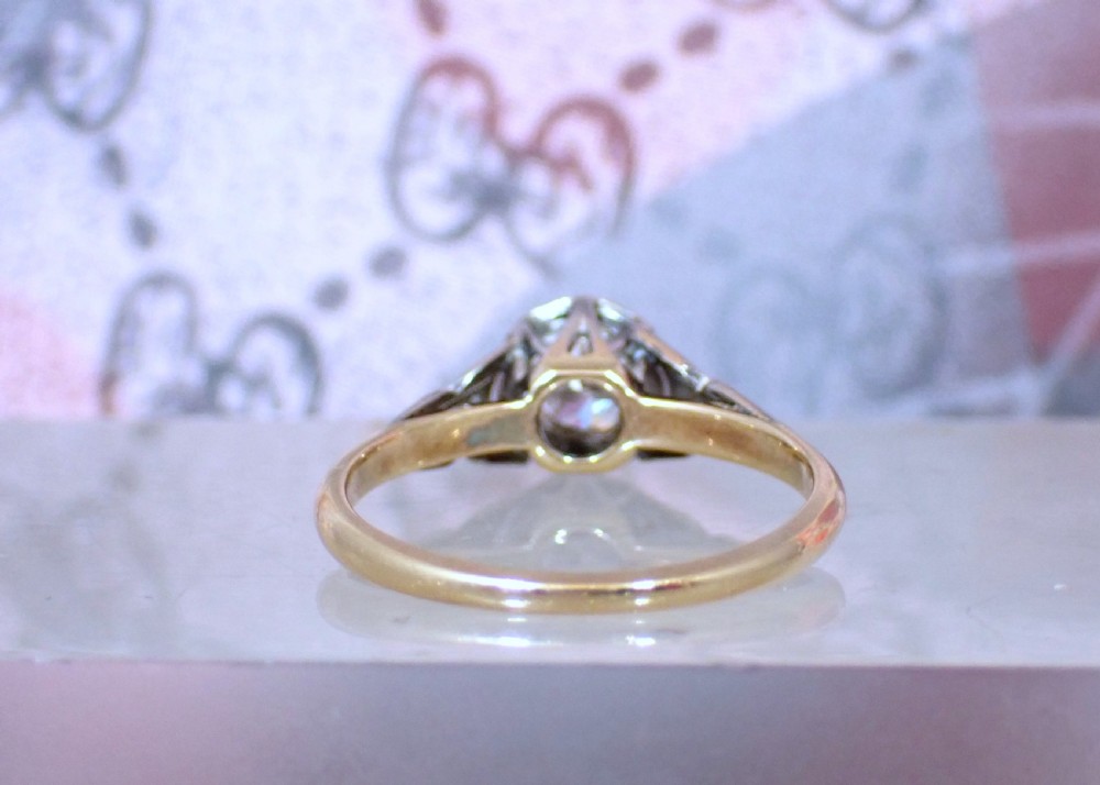 An Art Deco ring with a central diamond set in a platinum geometric head on an 18ct yellow gold band. View V