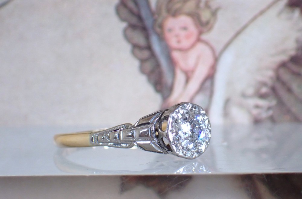 An Art Deco ring with a central diamond set in a platinum geometric head on an 18ct yellow gold band. View VI