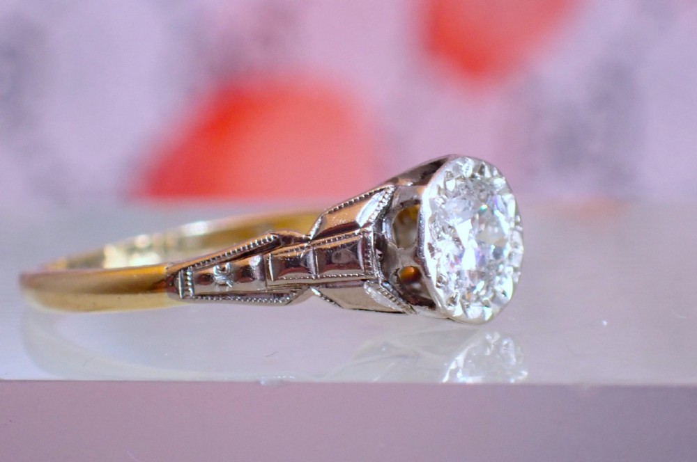 An Art Deco ring with a central diamond set in a platinum geometric head on an 18ct yellow gold band. View VIII
