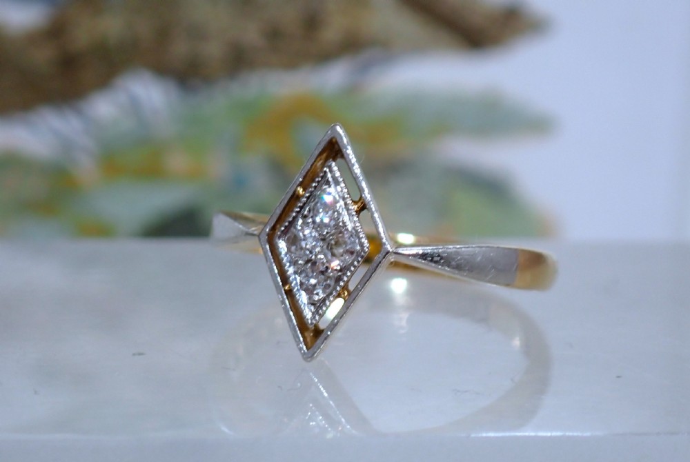 An Art Deco ring featuring a diamond-shaped lozenge motif set with four diamonds in platinum on an 18ct yellow gold band. View IV